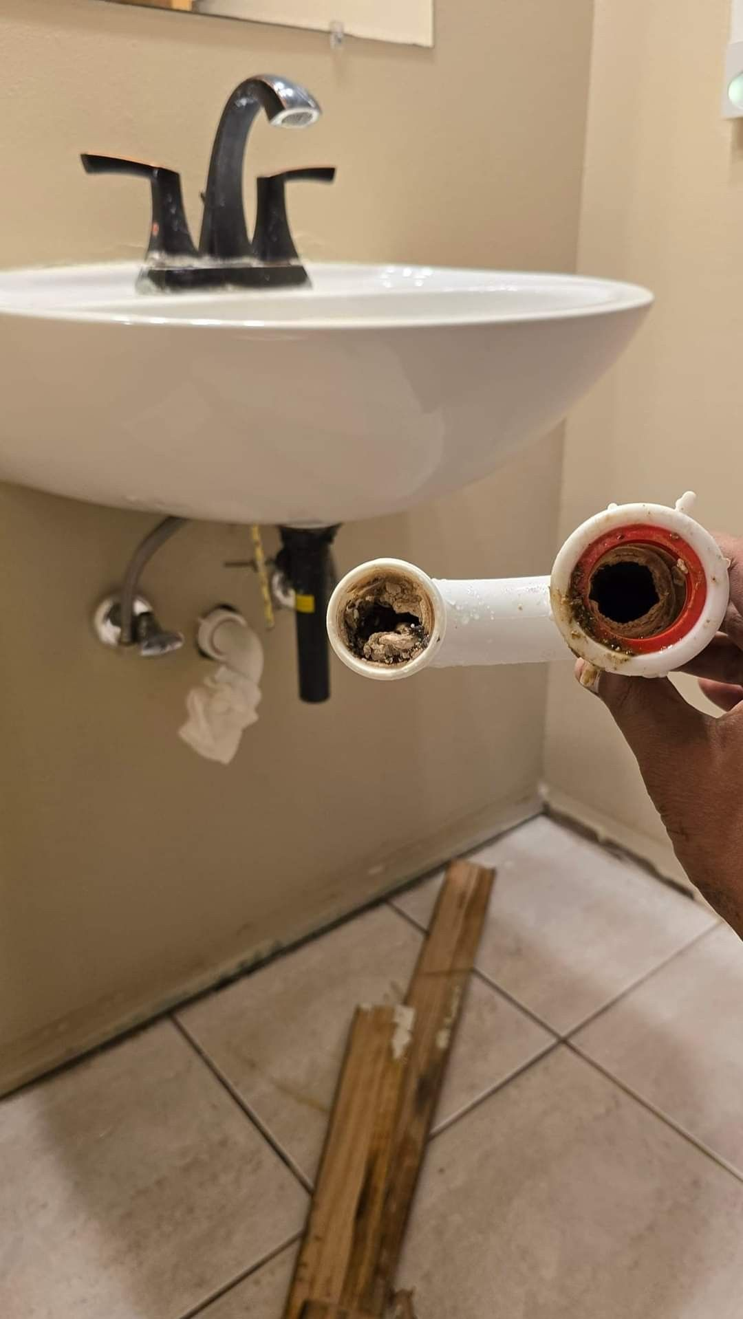 Siphon de lavabo démonté et obstrué avant débouchage